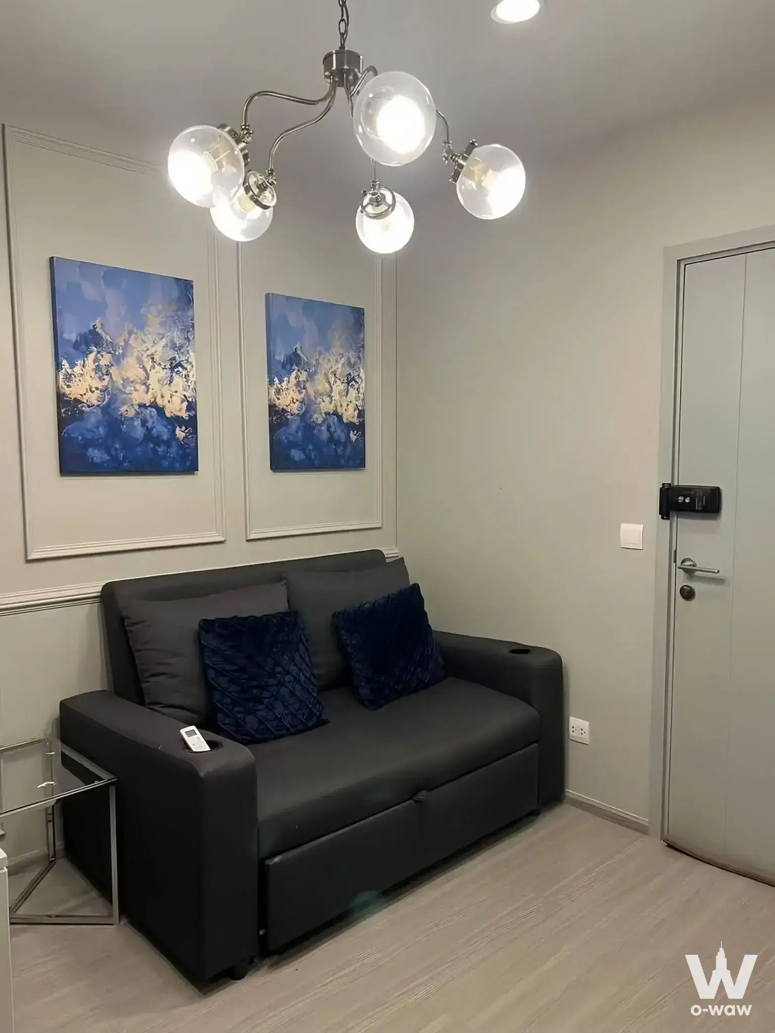Aspire Asoke-Ratchada 1-bed condo living room featuring navy velvet pillows and sputnik chandelier