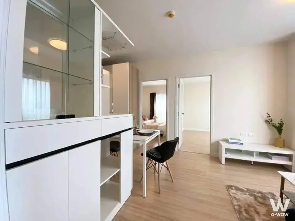 The living and dining area in a 2-bed condo for sale at 624 Condolette has white built-ins, a dining table and open doorways