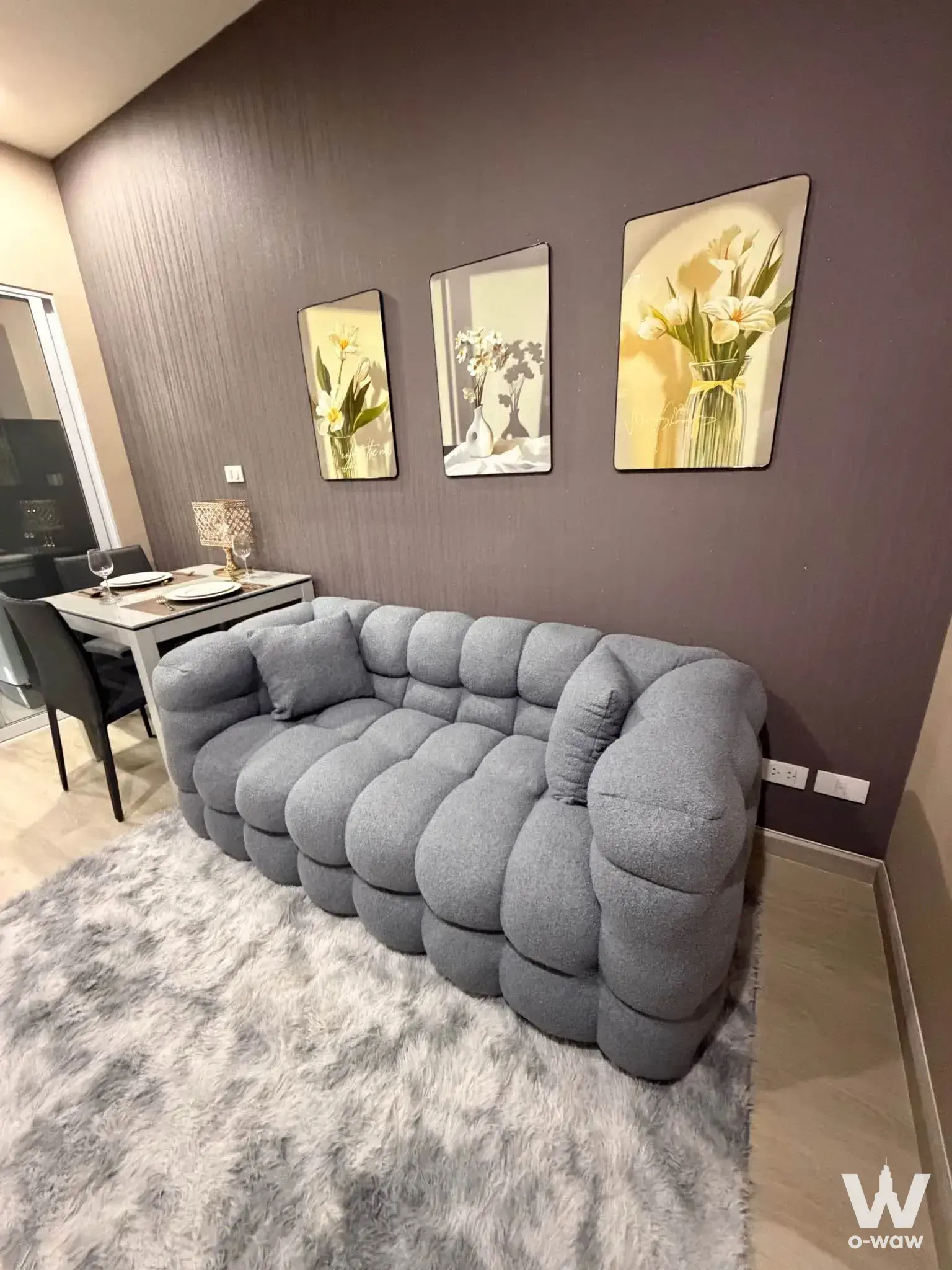 Living room with grey bubble sofa and floral art in a 1-bed Centric Ratchada-Huai Kwang condo
