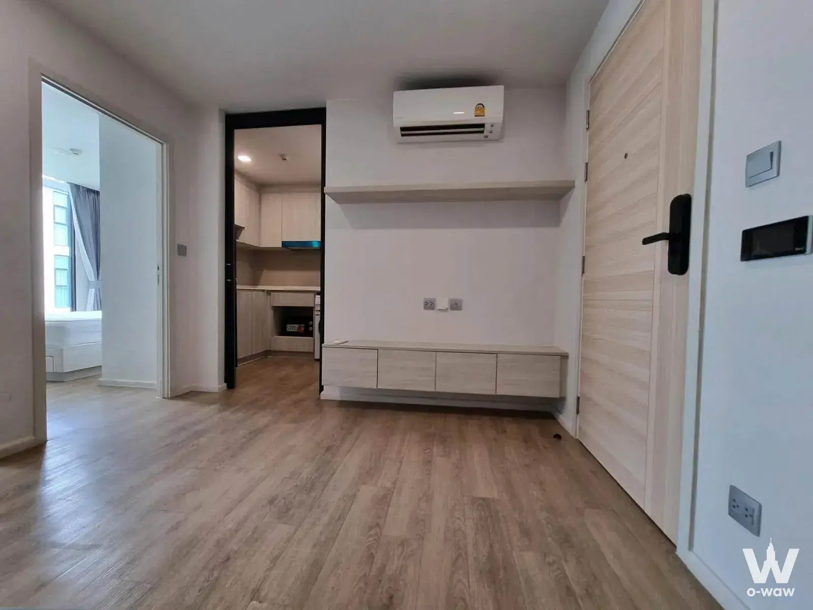 Bright entry hallway in a 1-bed Ivory Ratchada 32 condo featuring light wood floors and a floating media console