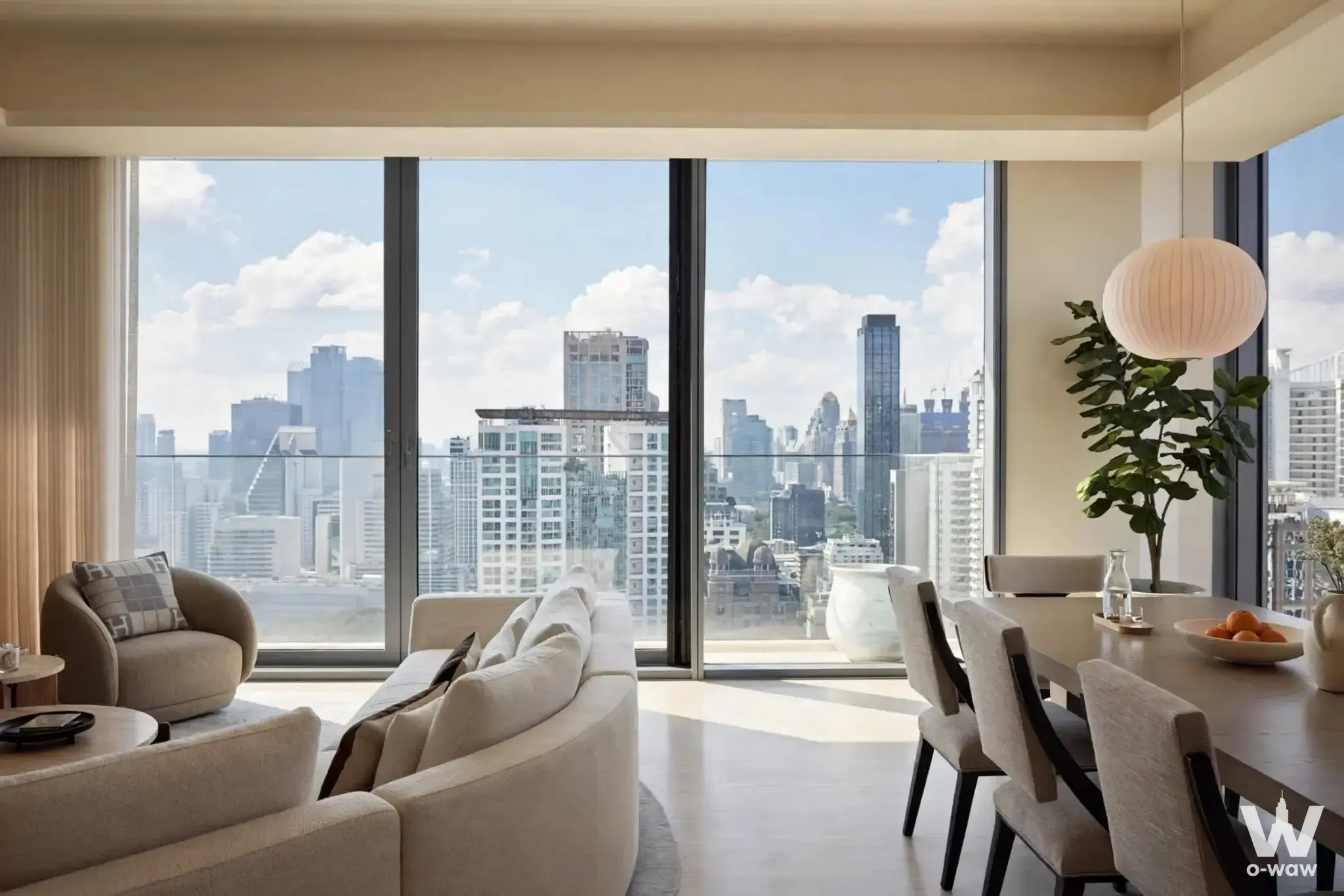 This 3-bed condo for sale in SCOPE Langsuan has a living and dining room with curved sofa and city views