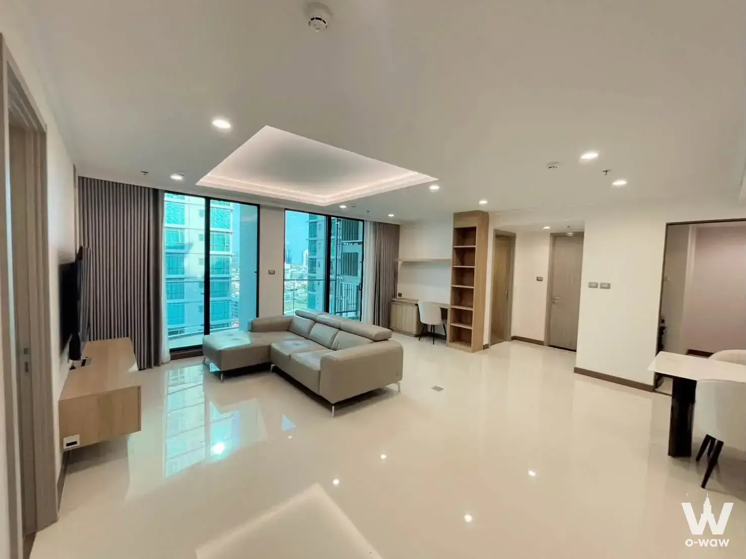 Open-plan living room in a Supalai Oriental Sukhumvit 39 condo with L-shaped leather sofa and city views