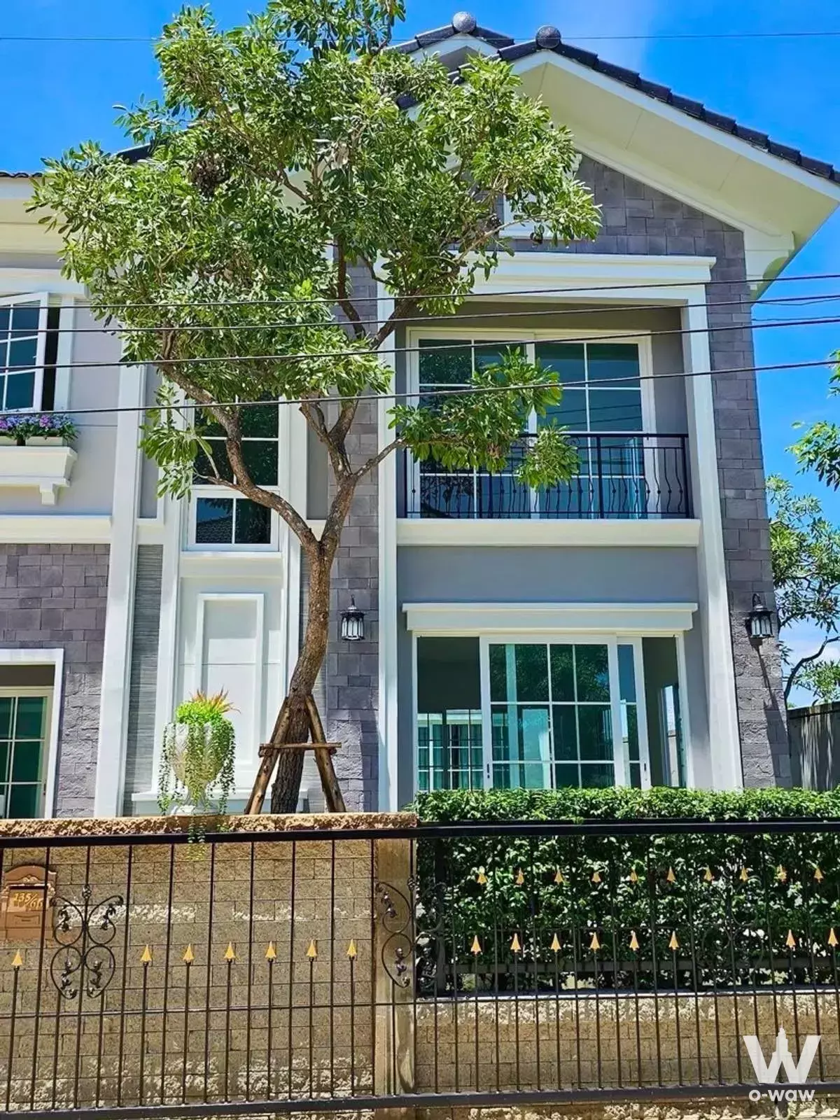 Modern two-story house exterior with grey stone facade and balcony at Prestige Future-Rangsit