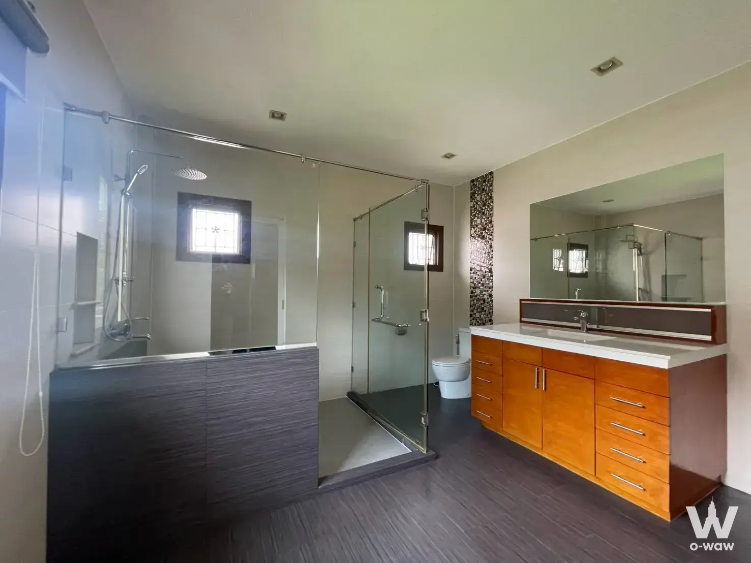 Modern master bathroom with glass shower and wood-look tile in Burasiri Ngamwongwan