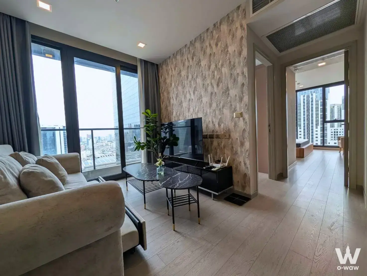 One9Five Asoke living room with cream sofa, city view balcony, and gold accents