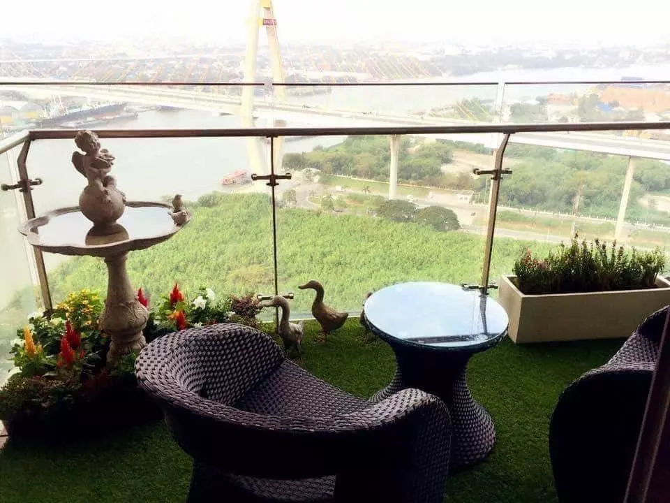 The Pano balcony terrace with wicker seating, fountain, and panoramic river bridge views