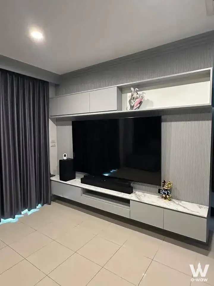 Living room featuring wall-mounted TV, fluted paneling, and custom cabinetry in a 3-bed house for rent in Laddarom