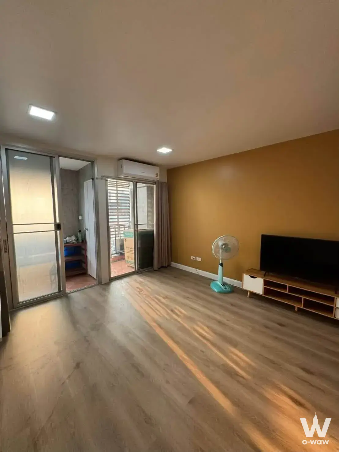 Living room with mustard accent wall and balcony door in a 1-bed house for rent at Regent Home 4