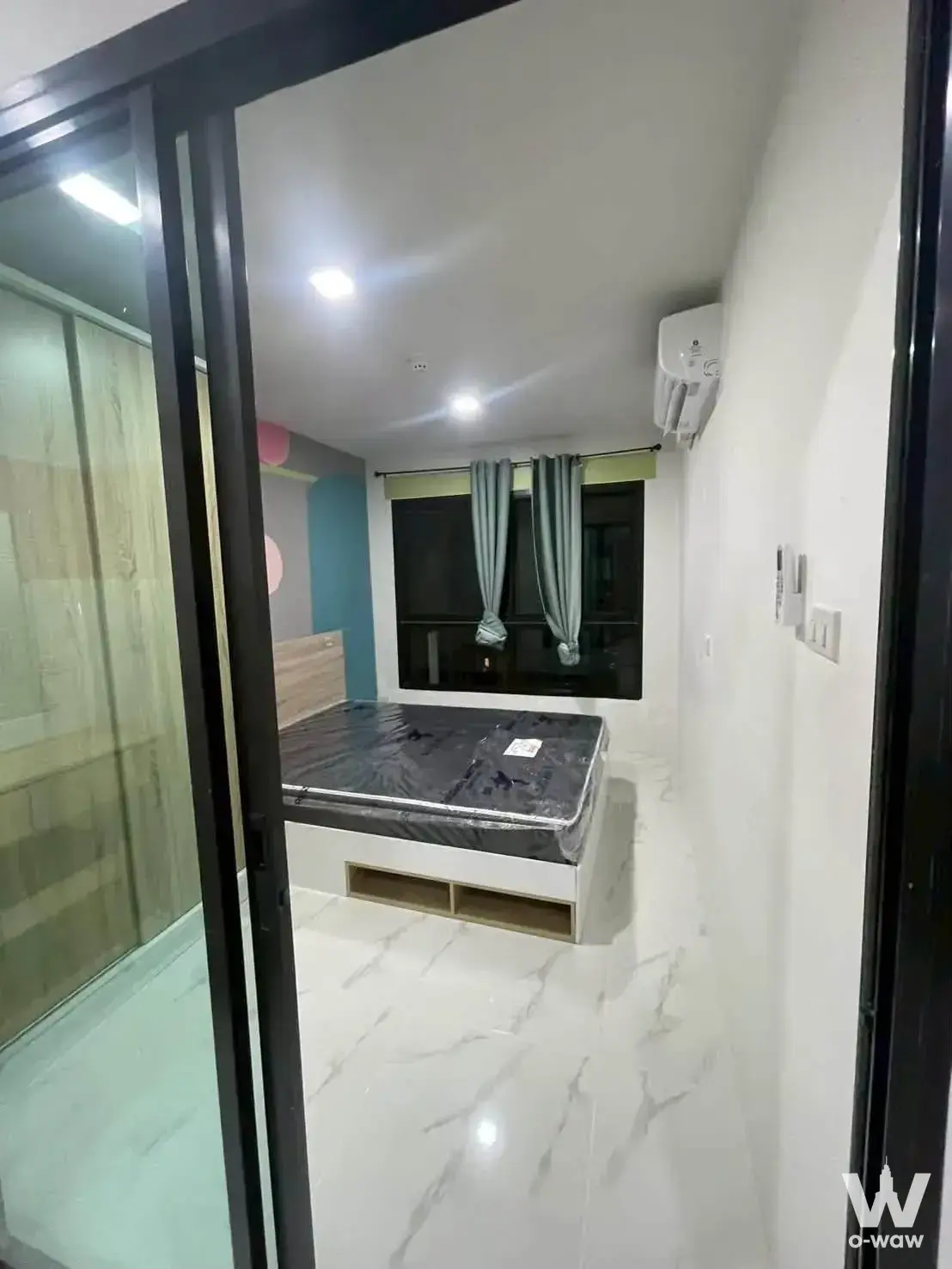 Bedroom in a 1-bed condo for rent at The Momento Tiwanon with platform bed and teal accent wall