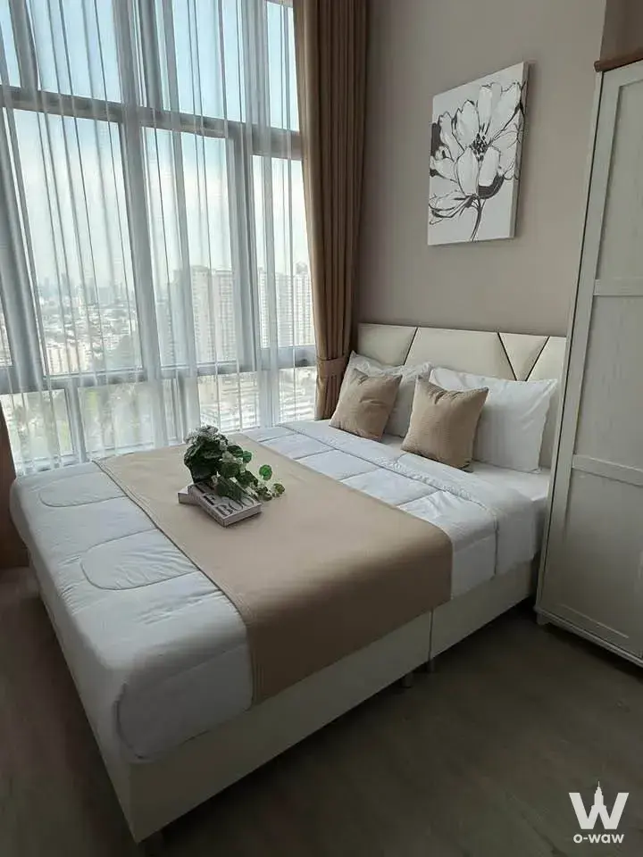 Bedroom with city skyline view in a Metro Sky Prachachuen 1-bed condo for rent