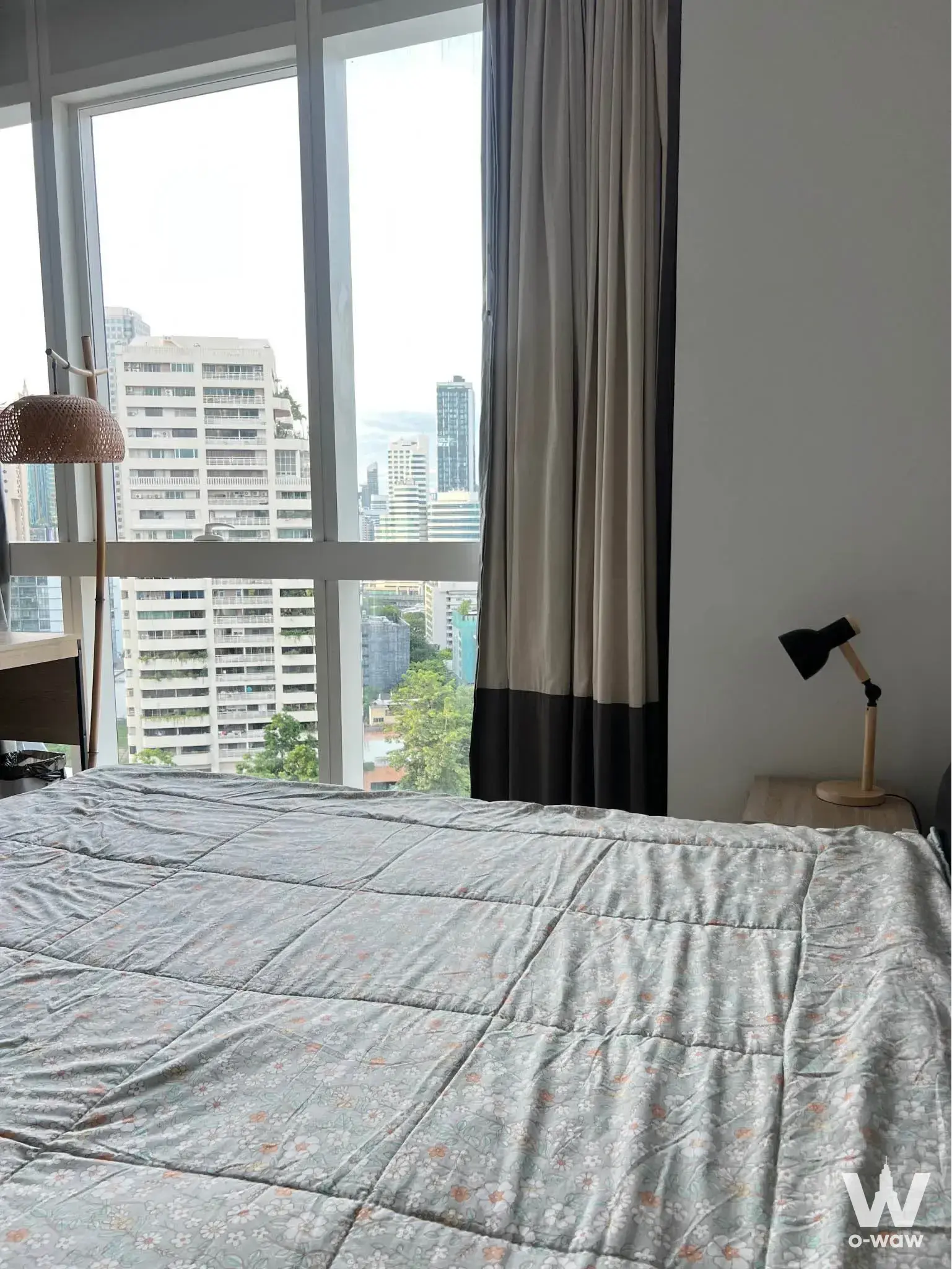 Queen bed with city view through floor-to-ceiling windows in a Millennium Residence condo