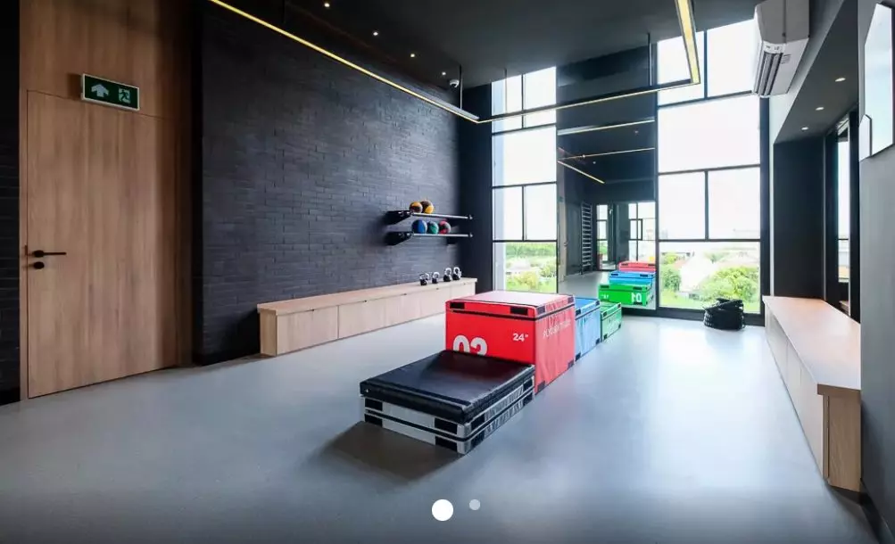 Modern gym amenity in Chapter One All Ramintra with plyo boxes, kettlebells, and large windows overlooking greenery