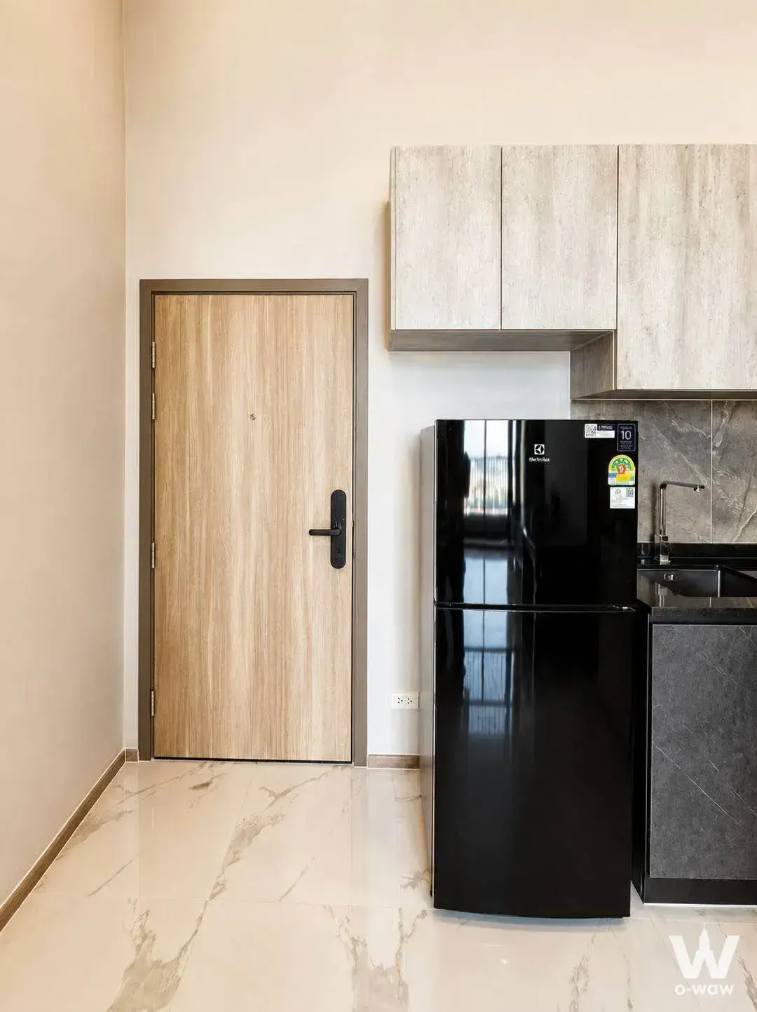 2-bed condo for rent in Ken Attitude Rattanathibet entryway with light wood grain door, glossy cream marble-look tile floor,
