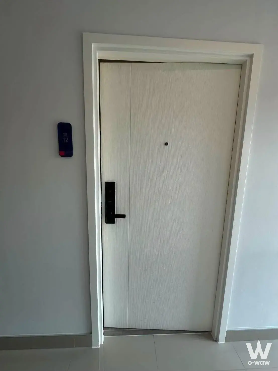 Modern minimalist condo entrance hallway with white wood-grain door and smart lock in Sukhumvit 89