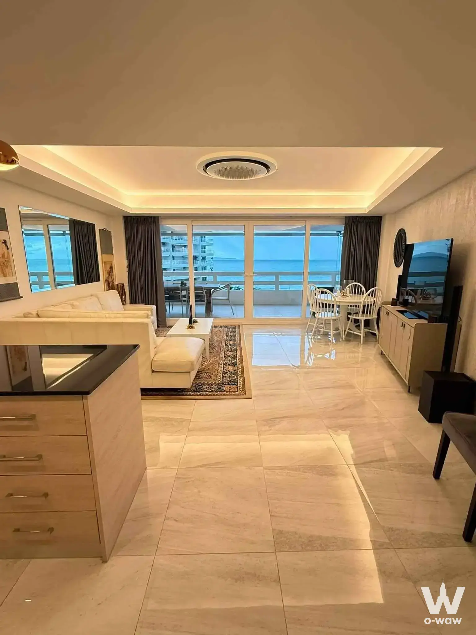 Grand Condotel open-plan living area with ocean view balcony and cream leather sofa