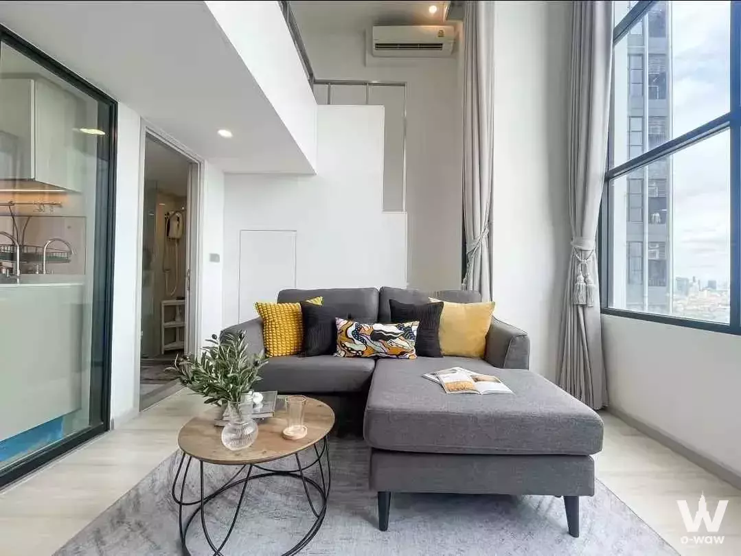 Modern 1-bed condo for rent in KnightsBridge Prime Sathon with city skyline view and grey sectional sofa