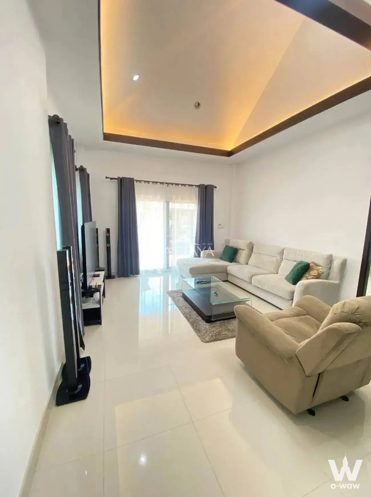 Modern living room with cream sectional sofa and emerald green pillows in a 3-bed home for sale at Baan Dusit Pattaya View