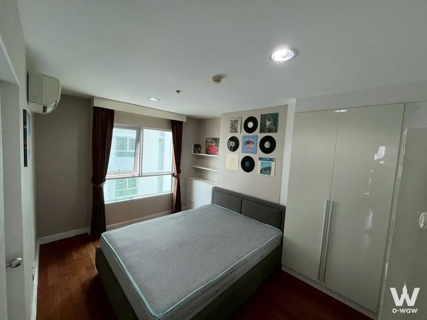 2-bed condo for rent in Belle Grand Rama 9 bedroom with dark wood laminate flooring and floor-to-ceiling glossy wardrobe
