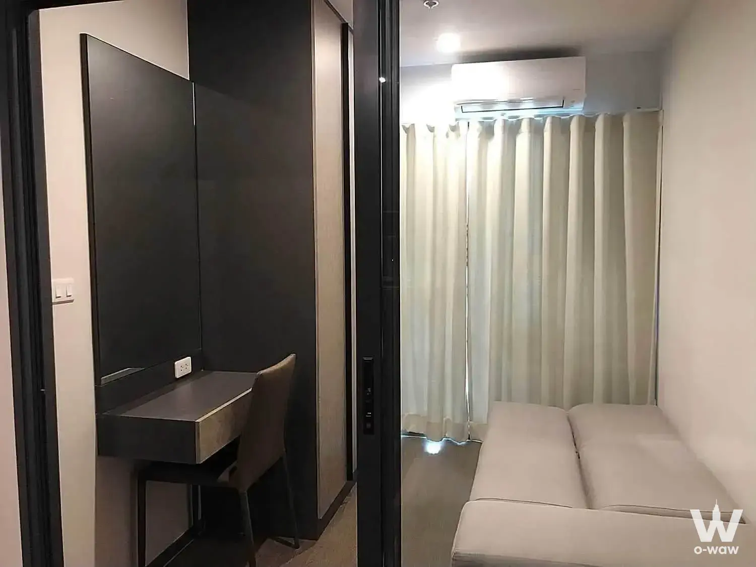 Studio room in a 1-bed Ideo Phaholyothin Chatuchak condo features a built-in desk and full sheer curtains