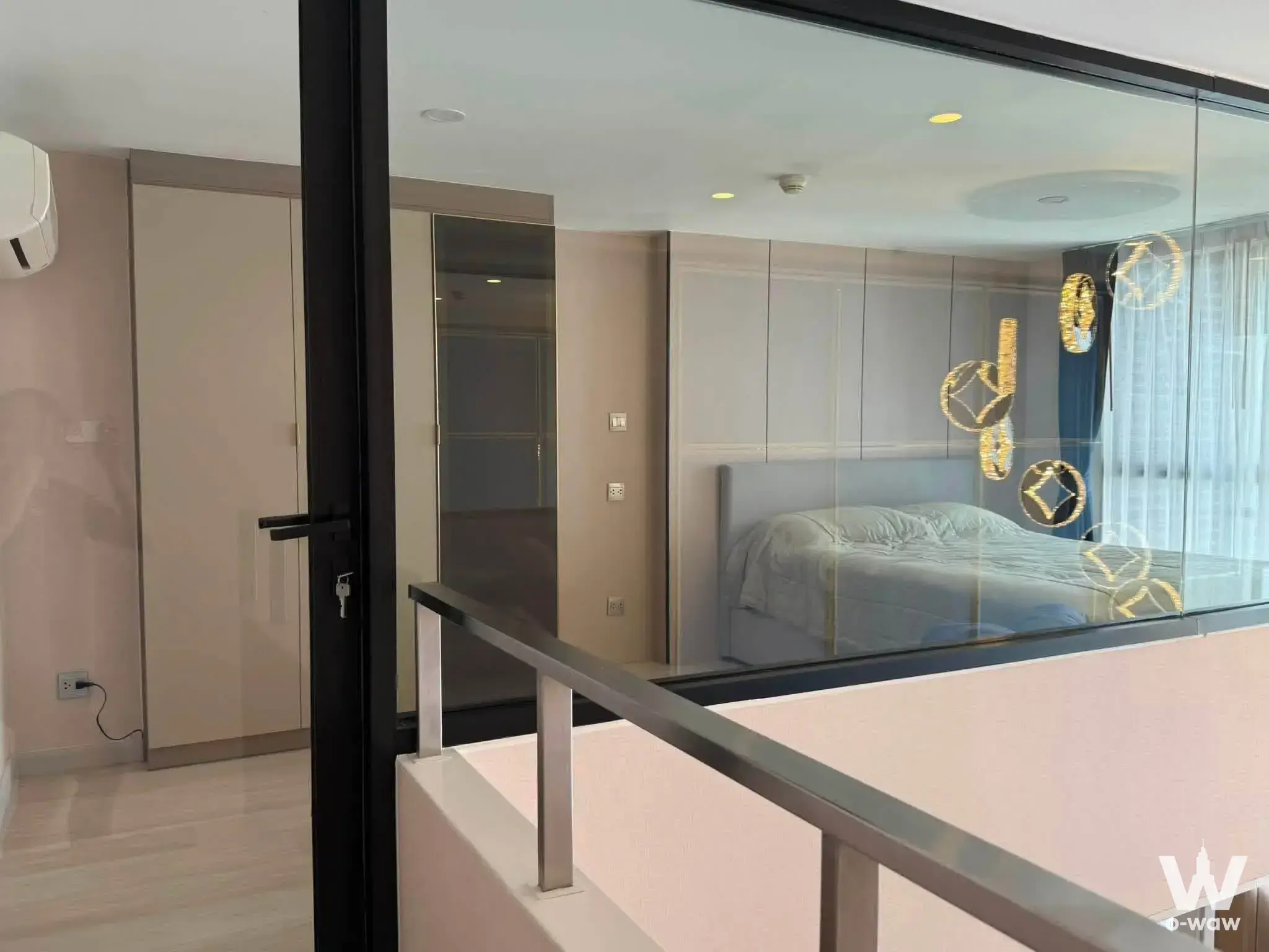 KnightsBridge Prime Sathon mezzanine bedroom with gold geometric wall art and grey bedding