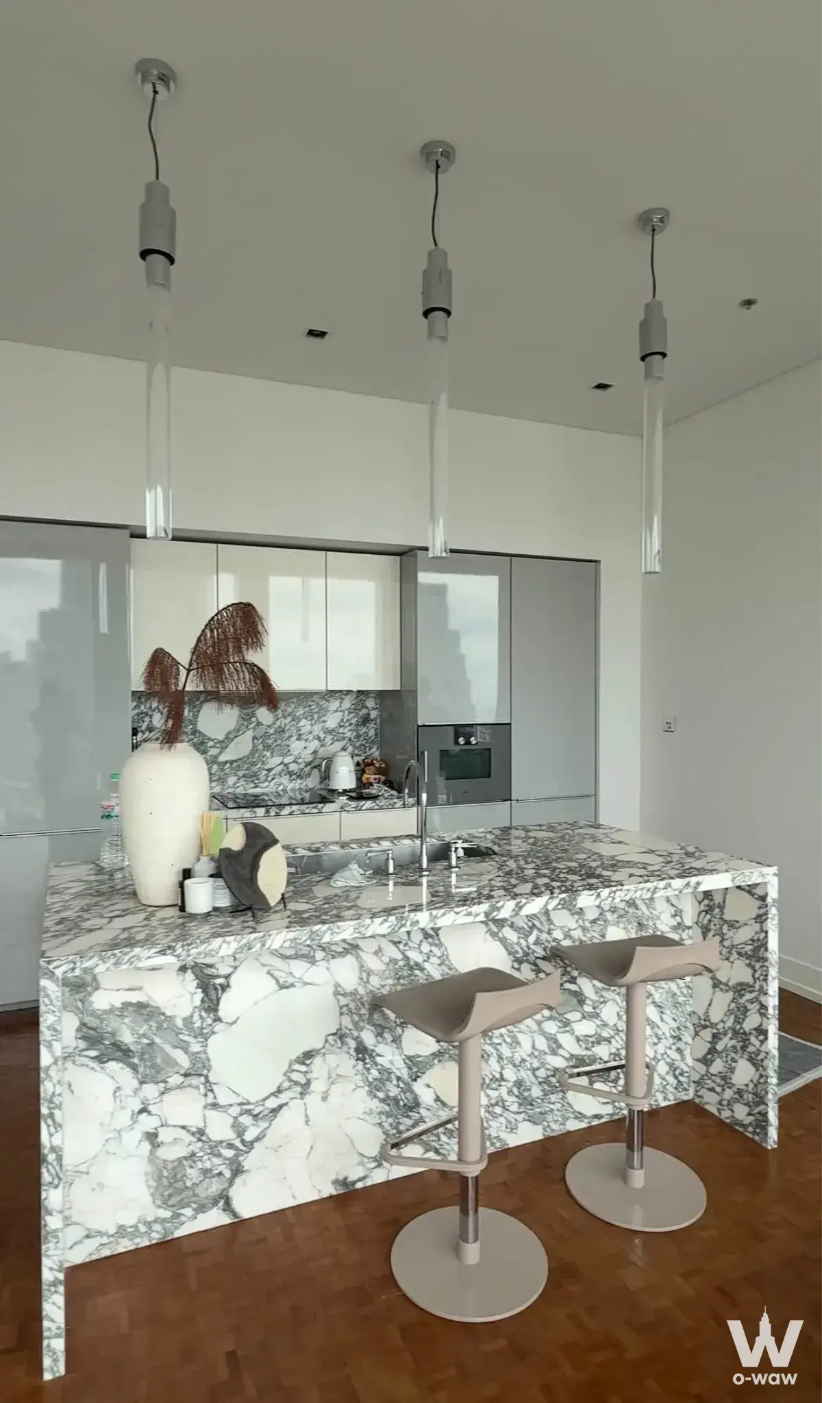 2-bed condo for rent in The Ritz-Carlton Residences Bangkok kitchen with marble island, herringbone parquet floor, and