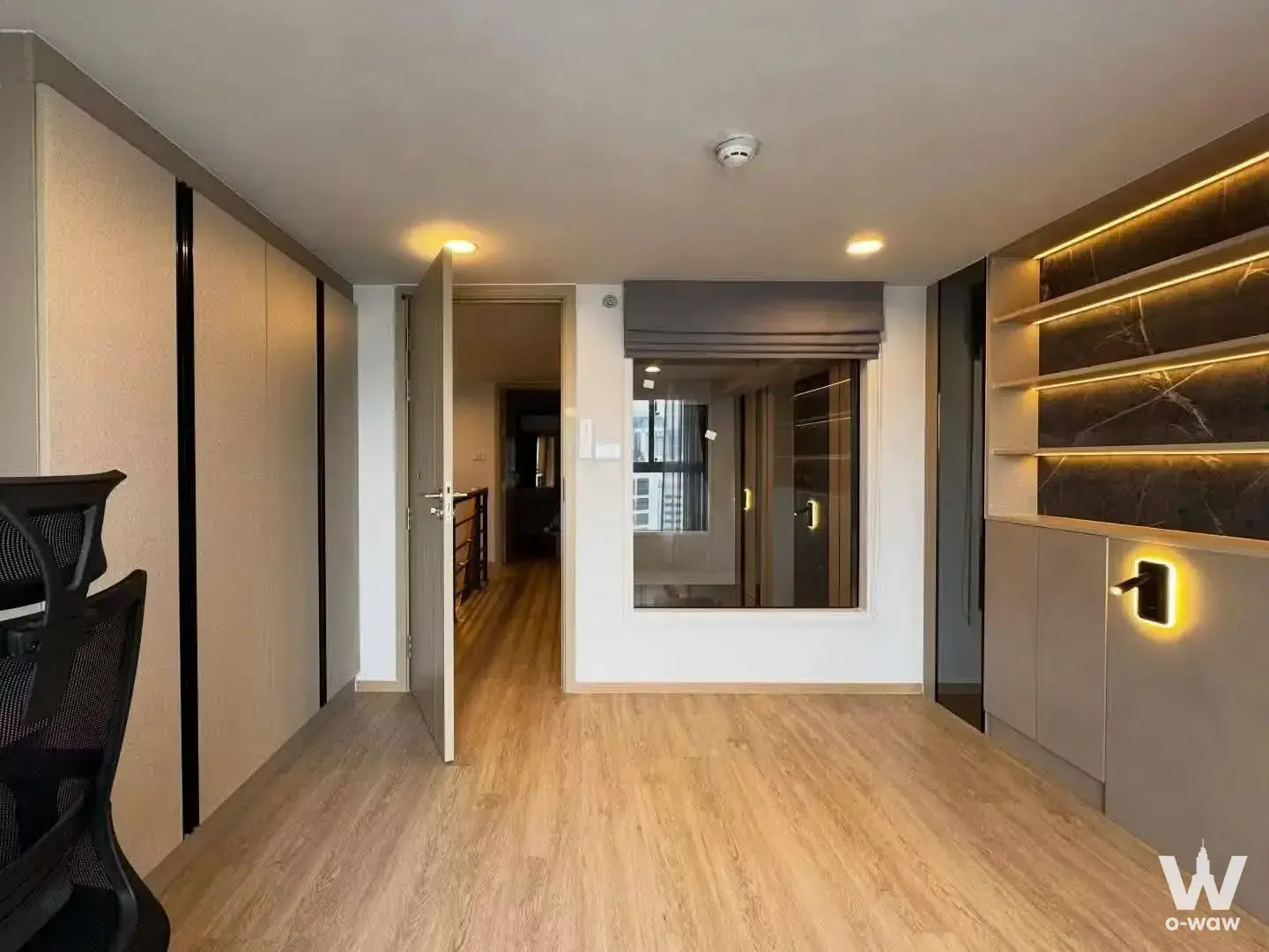 The 2-bed Culture Chula rental home office has an open door and lit built-in shelving