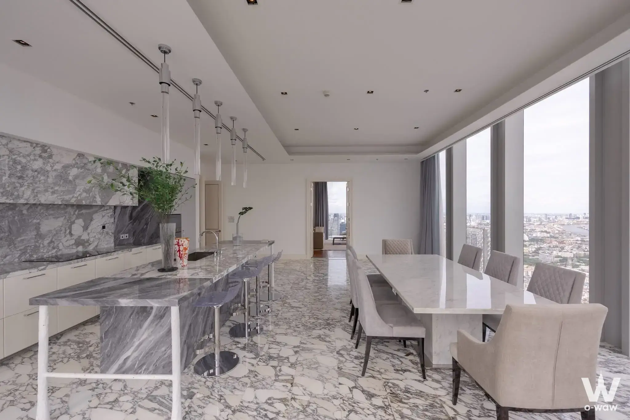 Kitchen-dining room with marble island, pendant lights, and city view
