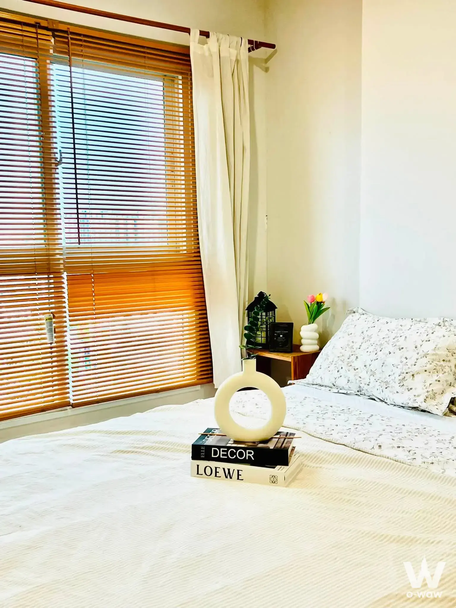 Bright bedroom in a 1-bed condo for rent at The Parkland Ratchada with wooden blinds and floral pillows