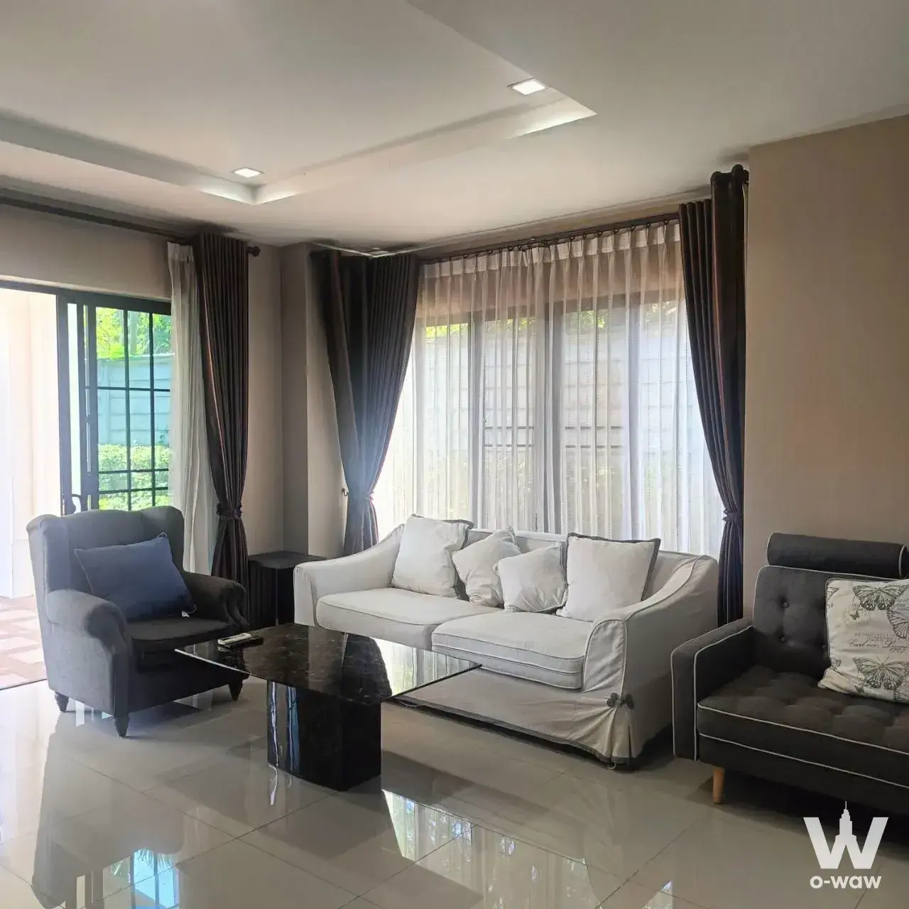 Modern 3-bed house living room in Setthasiri Watcharapol-Theprak with glossy white tiles and tray ceiling