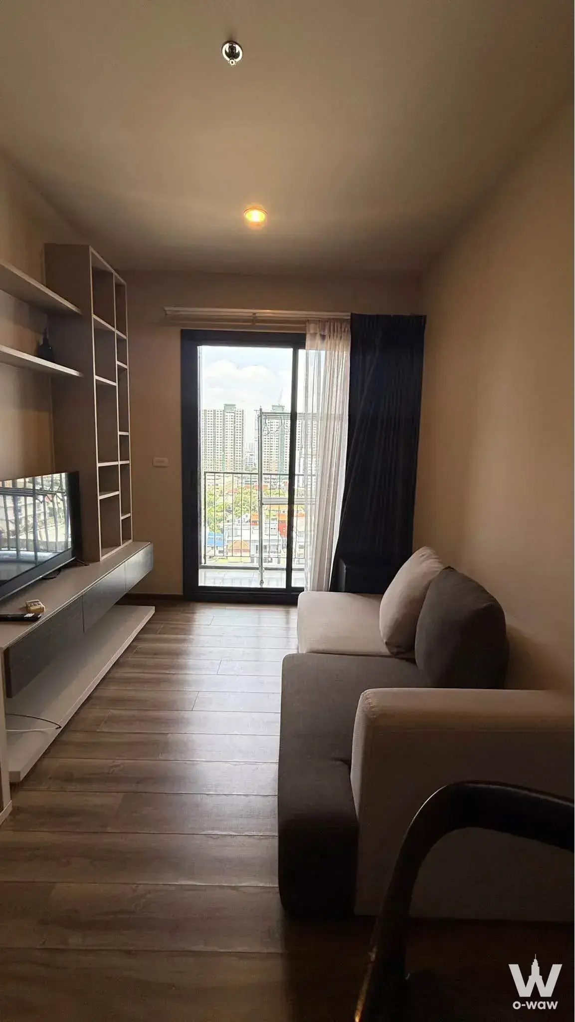Grey sofa and built-in media unit in a 1-bed condo for sale at The Editor Saphan Khwai