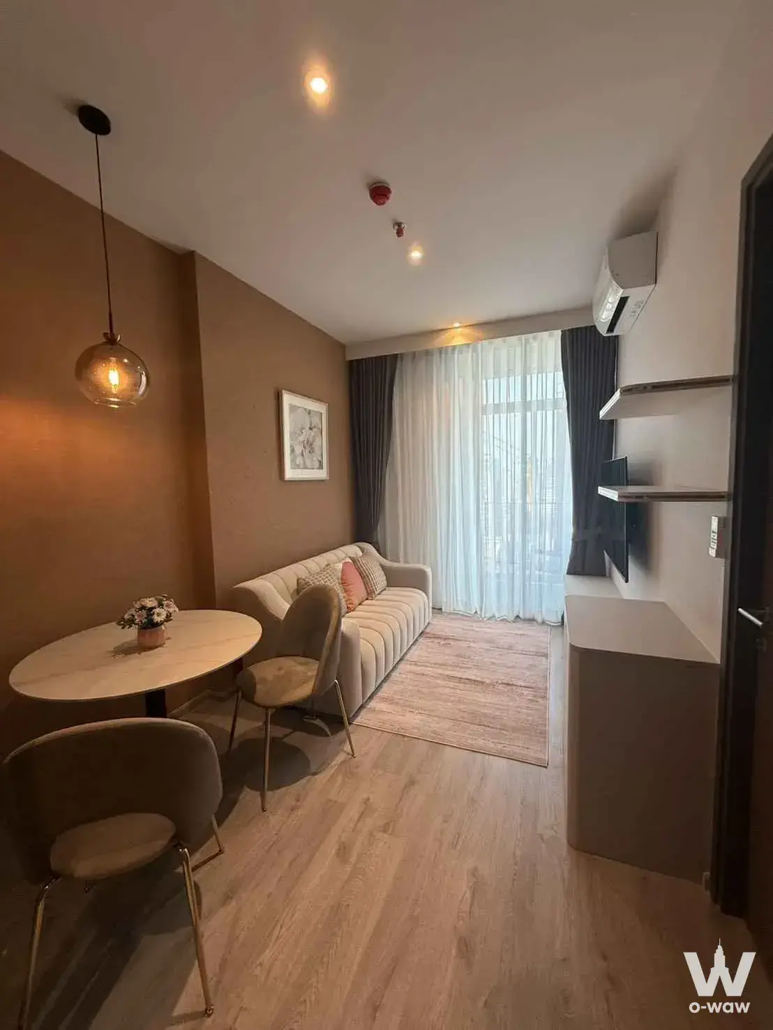 Cream velvet sofa and marble dining nook in this furnished 1-bed condo at Rhythm Ekkamai Estate