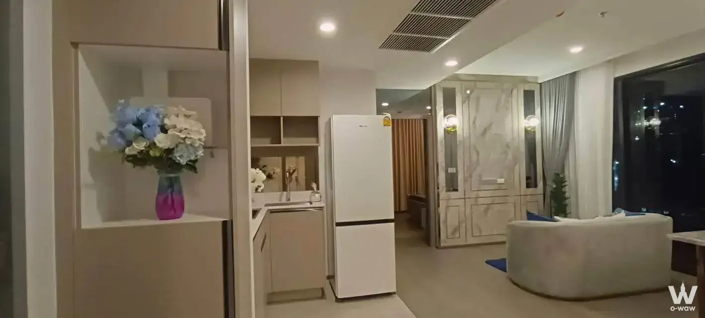 2-bed condo for rent in Supalai Oriental Sukhumvit 39 with open kitchen, curved sofa, and night city view