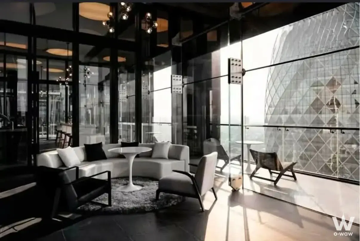 High-rise lounge in Noble Around Ari with curved sofa and floor-to-ceiling glass walls