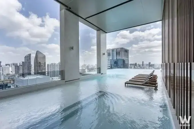 Rooftop infinity pool with city skyline view in a luxury 1-bed condo for rent at THE ESSE ASOKE