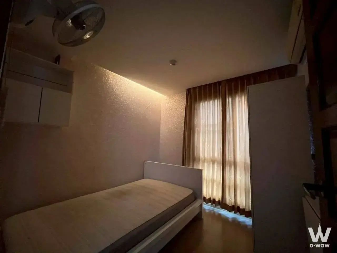 Compact bedroom in a 2-bed condo for rent at Emerald Residence Ratchada with single bed and dark wood floor