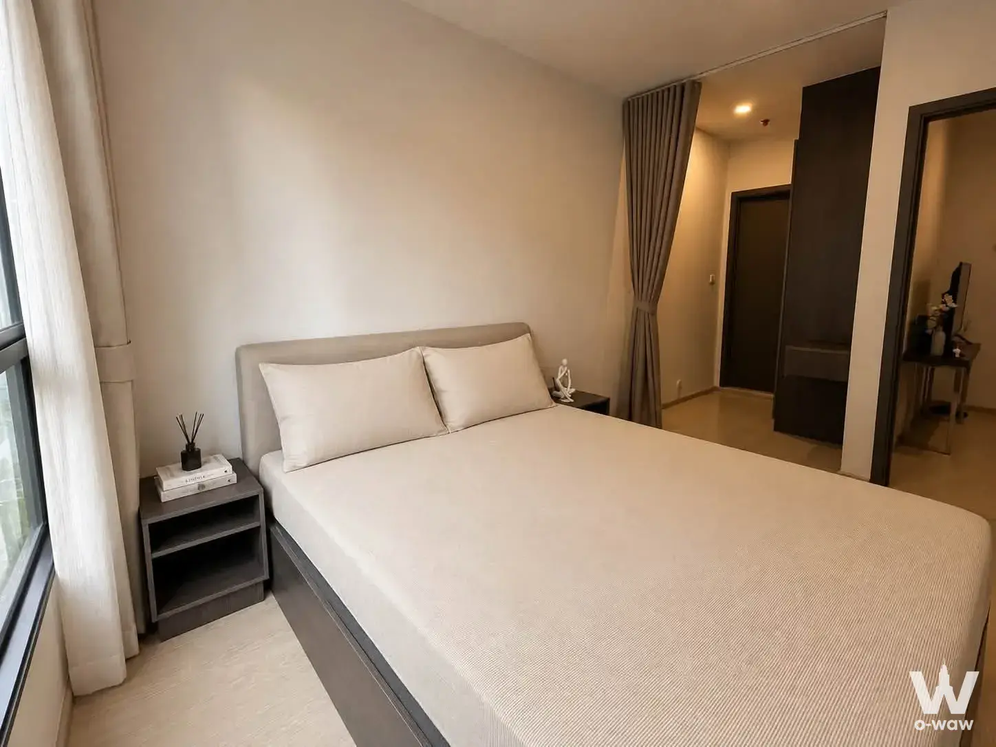 1-bed condo for rent in ELIO DEL NEST with grey upholstered bed and natural daylight window