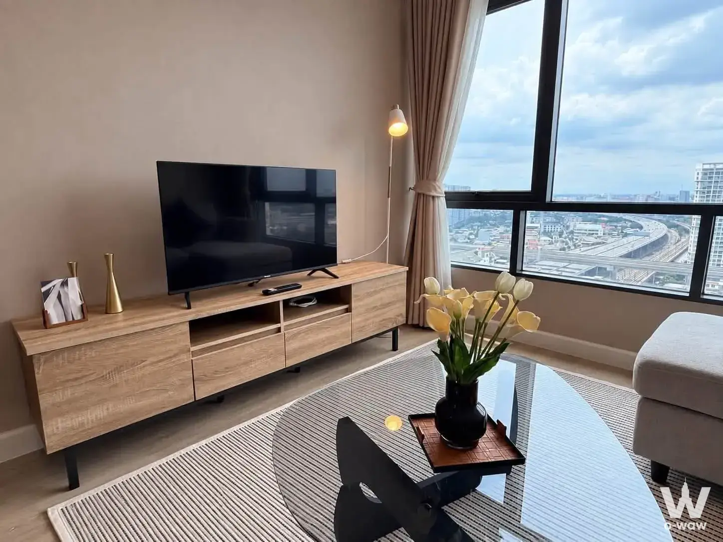 Living room in a 2-bed Metro Sky Prachachuen rental with a media console and high-floor city view