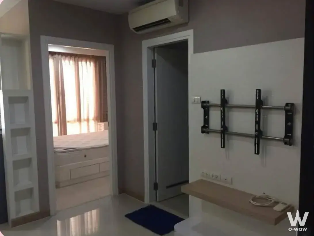 TV bracket and floating shelf in a modern 1-bed condo hallway for sale at Astra Condominium