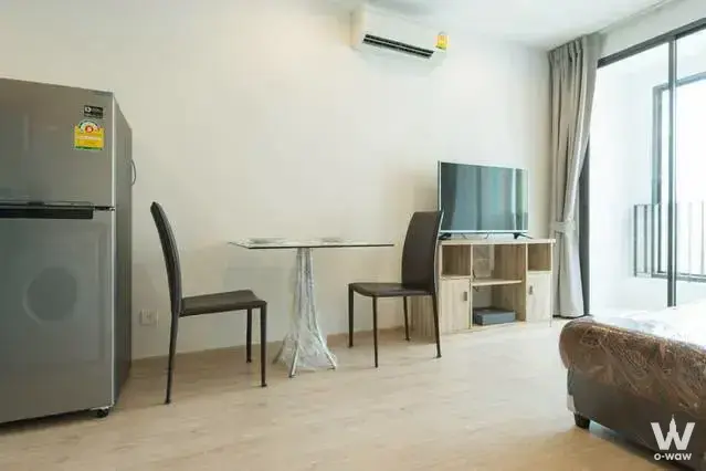 Furnished studio apartment for sale in Ideo Q Ratchathewi featuring glass dining table and balcony access