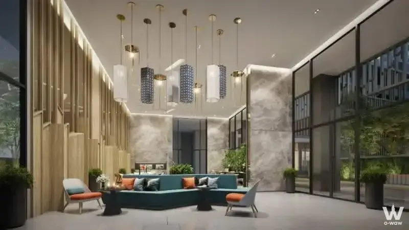 Teal curved sofa and pendant lights in the luxury lobby of a 1-bed condo for sale at Lumpini Place Taopoon Interchange