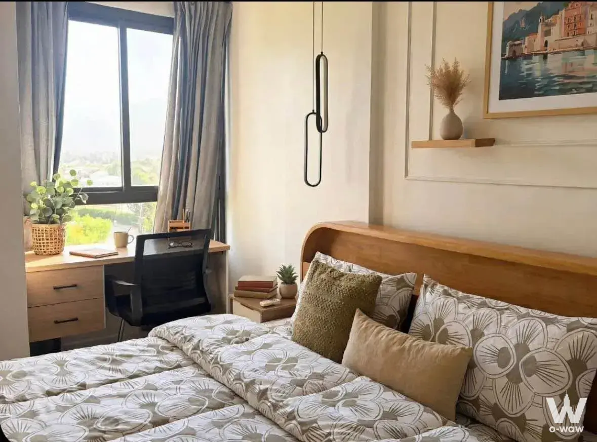 Modern furnished bedroom with queen bed and desk in Zcape 2 Condominium