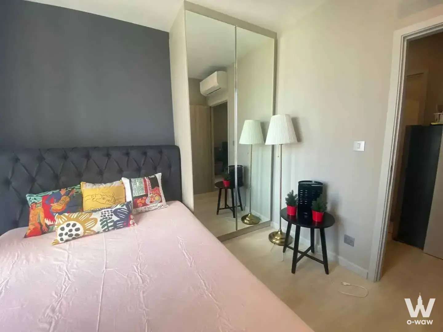 Modern bedroom in KnightsBridge Prime Sathon condo with pink duvet and mirrored wardrobe