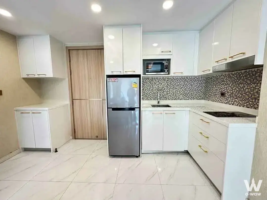 Dusit Grand Park 2-bed condo kitchen with white cabinets and granite counters