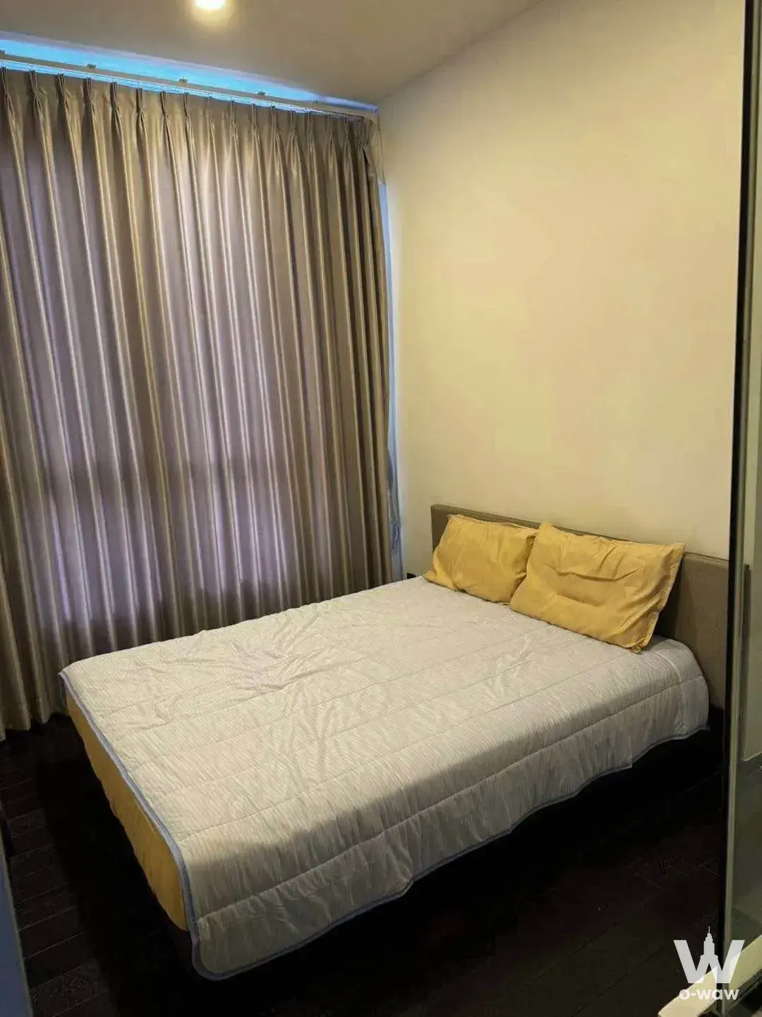 Compact bedroom in a 1-bed condo for rent at Park Origin Thonglor featuring a queen bed and taupe curtains