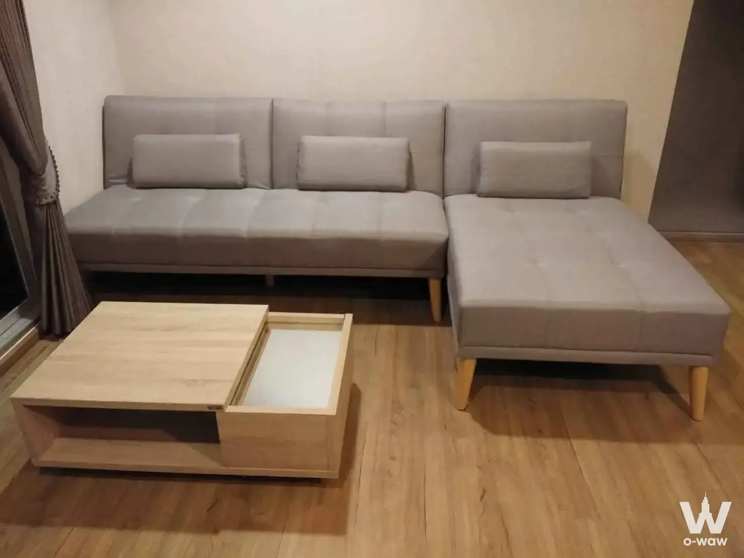 Modern living room in Fuse Chan Sathorn with light grey sectional sofa and oak coffee table