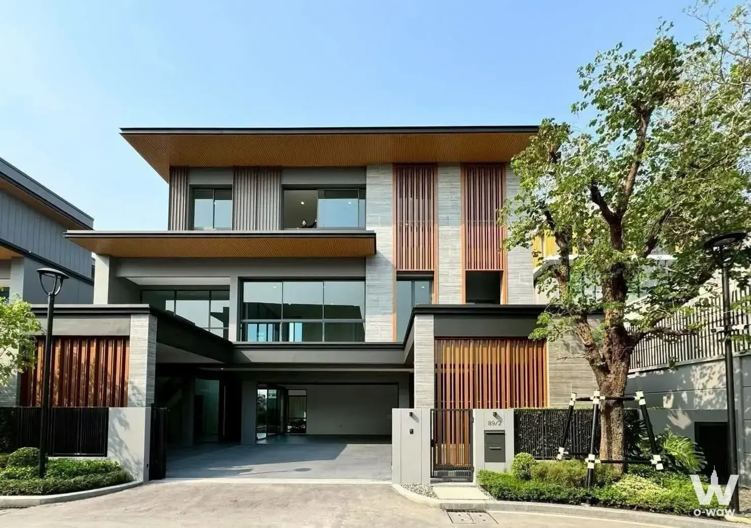 Modern two-story house exterior with wood slats and carport for sale in SMYTH'S Ramintra
