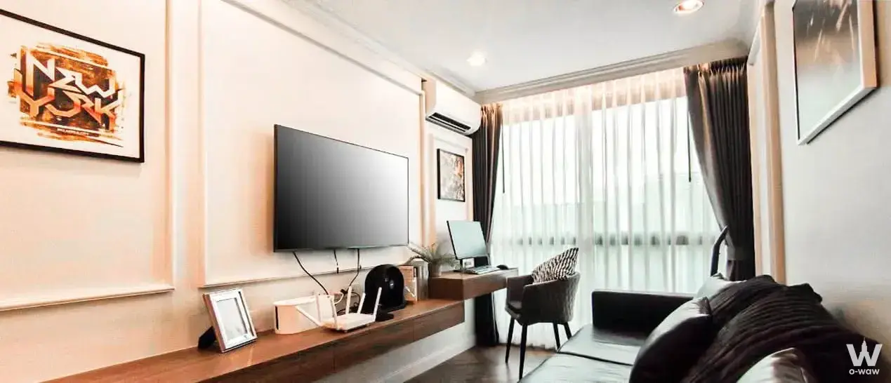 Fully furnished 1-bed condo for sale in The Excel Lat Phrao with modern living room and desk area