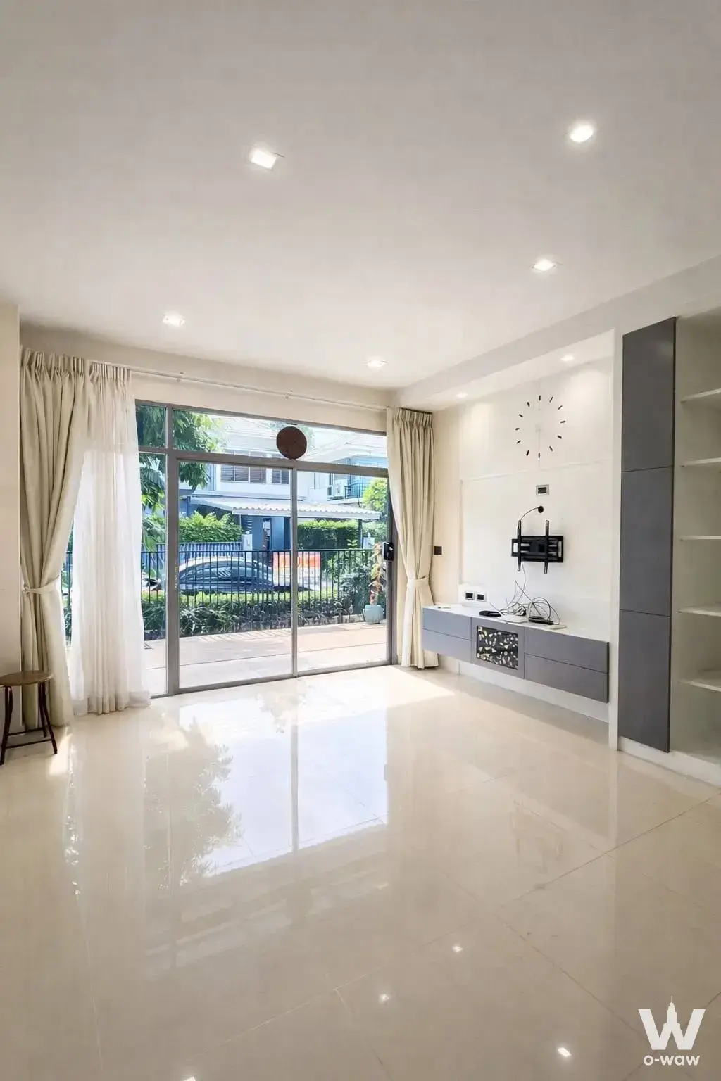 Living room with cream tile floors and balcony view in unfurnished house for sale at Perfect Place Pattanakarn