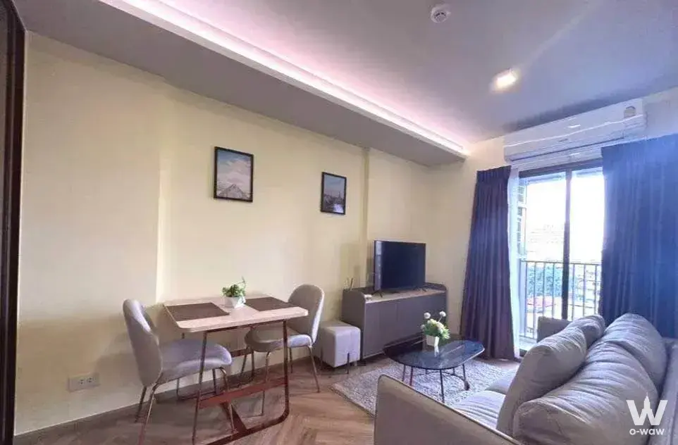 Furnished living area with a grey sofa and dining set in this Thonglor rental condo