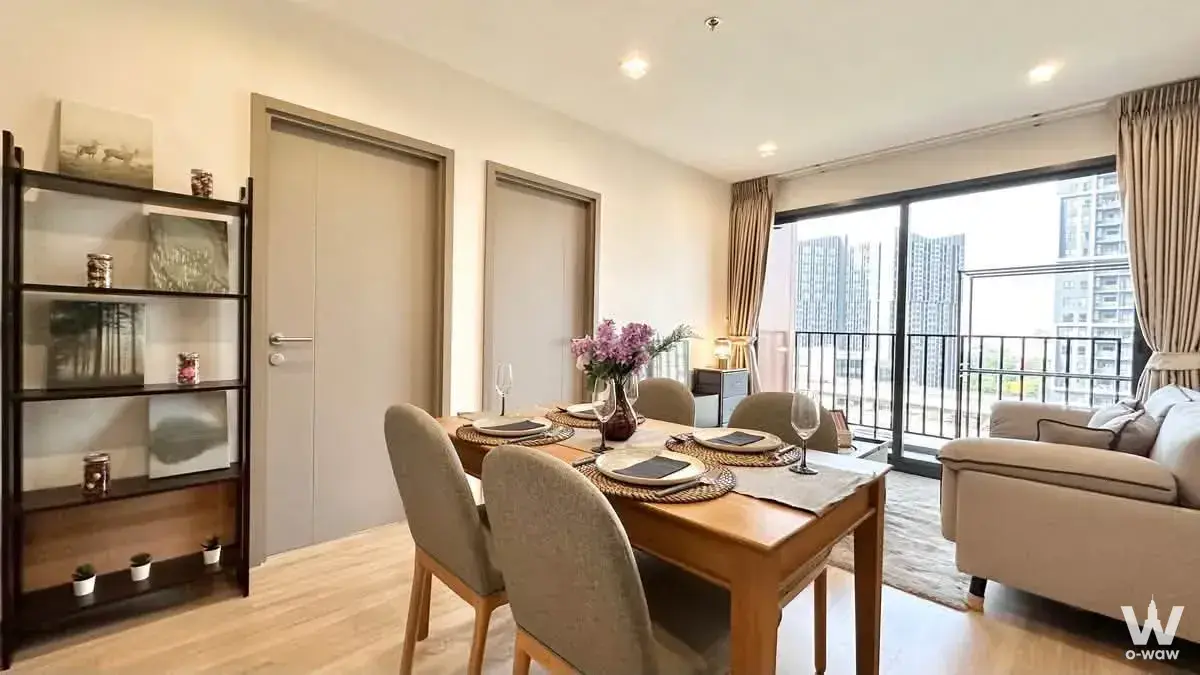 Open-plan dining area in a THE BASE Garden Rama 9 2-bed condo for sale with dining table and city view